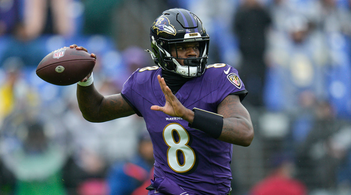 Lamar Jackson lifts his arm to throw a pass